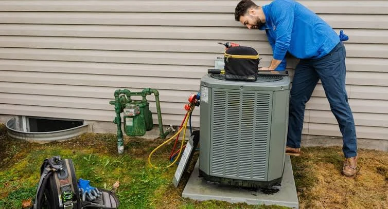 Technician inspecting an outdoor residential air conditioner